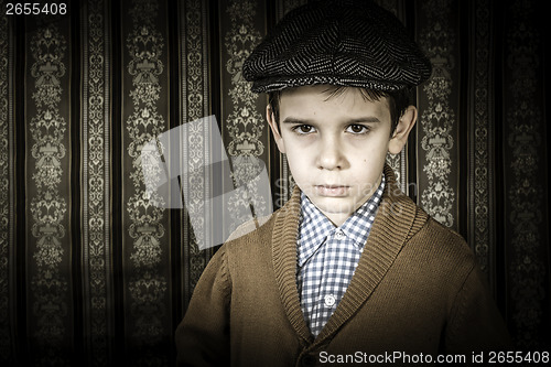 Image of Frowning child in vintage clothes and hat