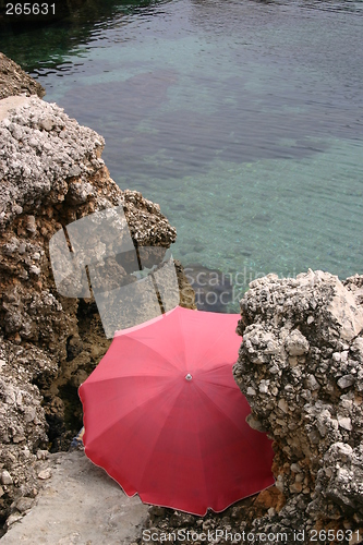 Image of Red parasol by the sea