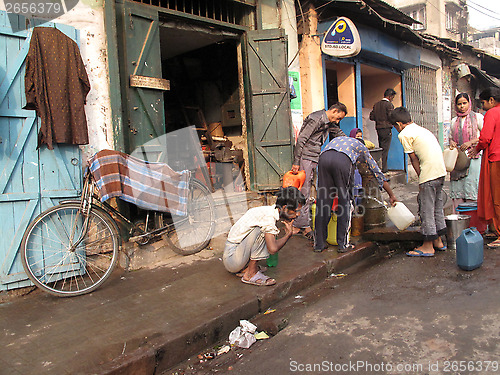 Image of Streets of Kolkata. People filling up water in cans