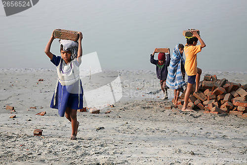 Image of Child workers carry bricks carrying it on his head in Sonakhali, West Bengal, India