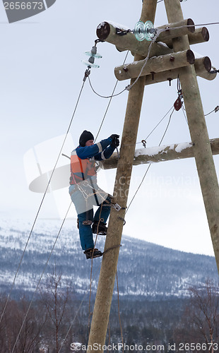 Image of Electricians working on a pole in winter 