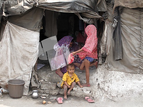 Image of Streets of Kolkata. Poor Indian family living in a makeshift shack by the side of the road