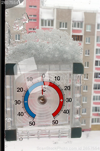 Image of thermometer with layer of snow showing two degrees
