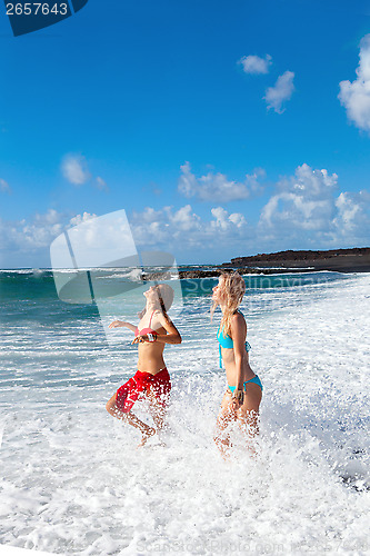 Image of happy girls on the beach with black sand 