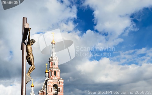 Image of Statue of the crucifixion and church.