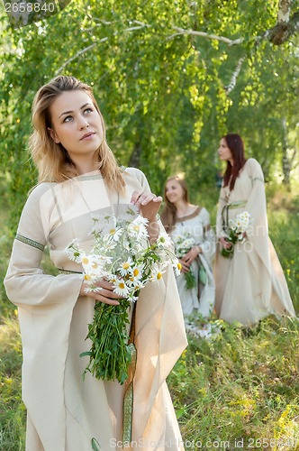 Image of Beautiful woman with bouquet of camomiles