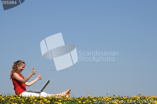 Image of Smiling girl with laptop, thumbs up