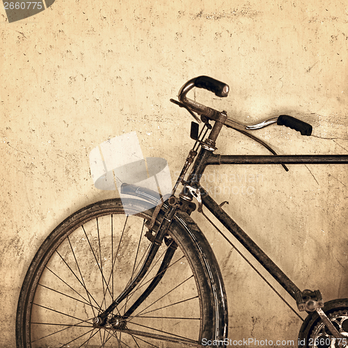 Image of Old rusty bicycle on grunge wall background