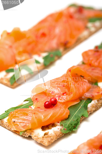 Image of Salted salmon on crispy bread with cheese and arugula