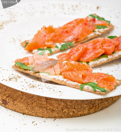 Image of Salted salmon on crispy bread with cheese and arugula