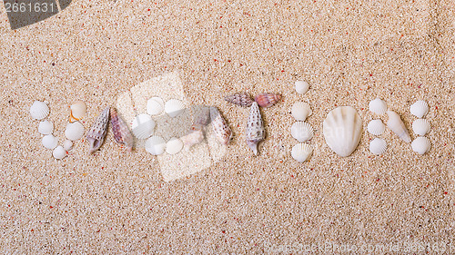 Image of Title "vacation" from sea shells with coral sand