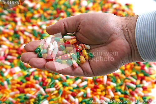 Image of Hands full of medication pill capsules