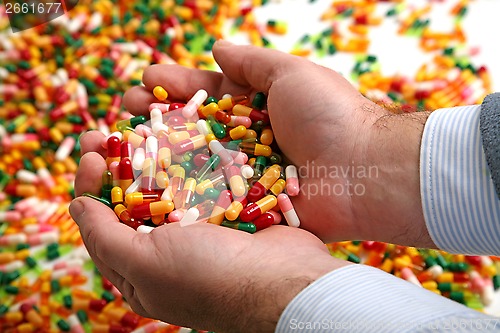 Image of Hands full of medication pill capsules