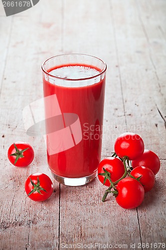Image of tomato juice in glass and fresh tomatoes 