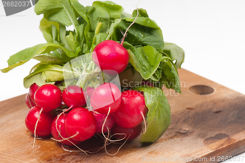 Image of Fresh radishes on old wooden board