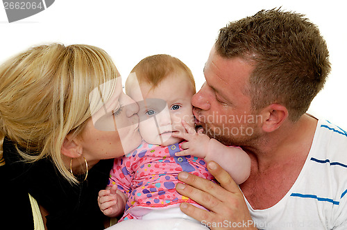 Image of Mother and father are kissing baby