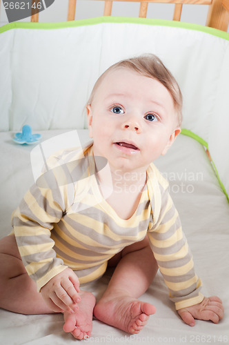 Image of Baby boy in cradle looking up