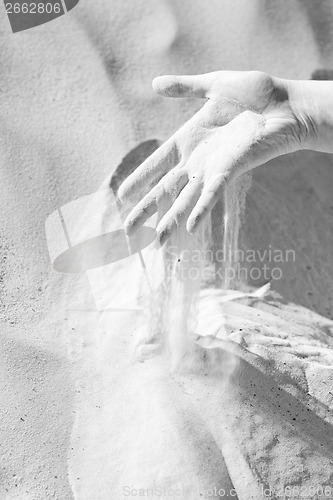Image of Sand slipping through fingers black and white