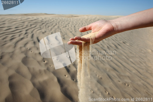 Image of Woman hand in the sand