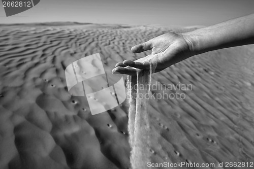 Image of Womans hand in the sand black and white