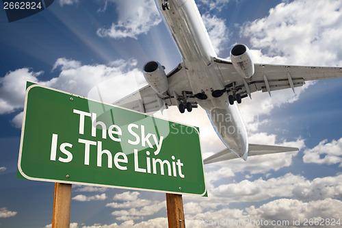 Image of The Sky Is The Limit Green Road Sign and Airplane