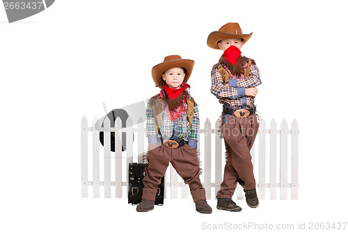 Image of Two boys wearing cowboy costumes