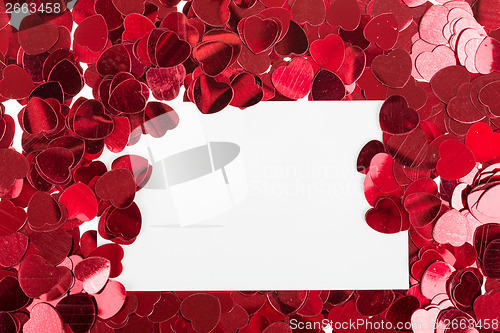 Image of small red confetti and big hearts on white background