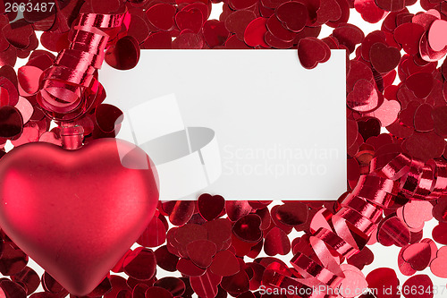 Image of small red confetti and big hearts on white background