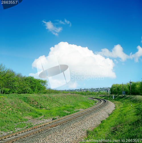 Image of railroad in green landscape and clouds over it