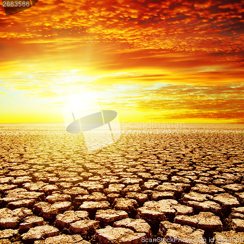 Image of red sunset over drought earth