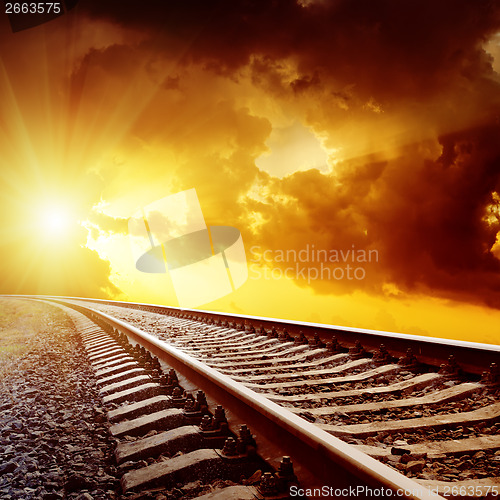 Image of sunset with dark clouds over railroad