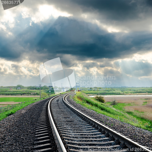 Image of railroad and rainy clouds over it