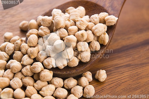 Image of dried white chickpeas ceci on the wooden spoon