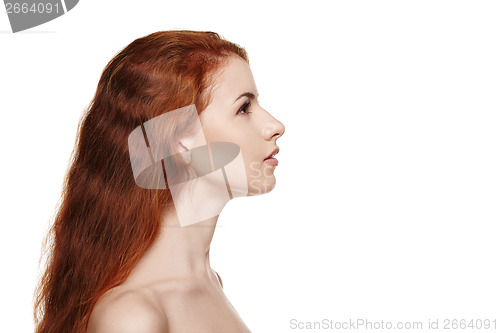 Image of Side view closeup of beautiful redheaded woman looking forward