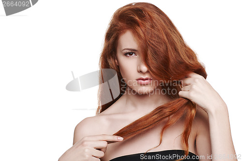 Image of Beautiful woman holding her red hair in hand