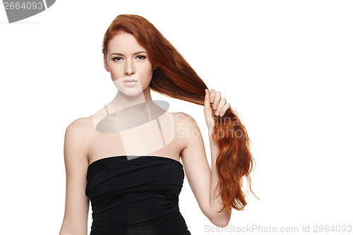 Image of Beautiful woman holding her red hair in hand