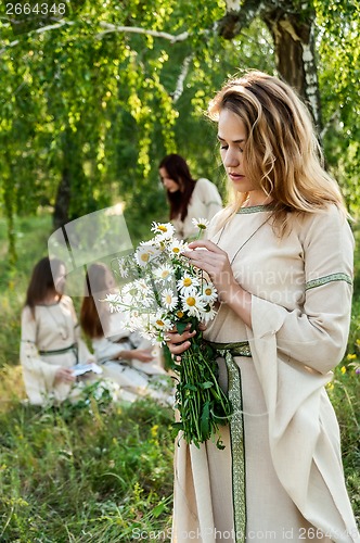 Image of Beautiful woman with bouquet of camomiles