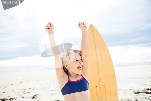 Image of Happy young girl with surfboard on beach