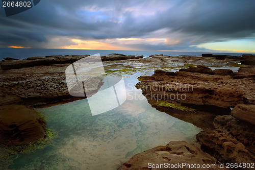 Image of Stormy sunrise over Little Bay with rockpool in foreground