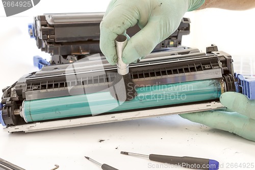 Image of hands cleaning toner cartridge