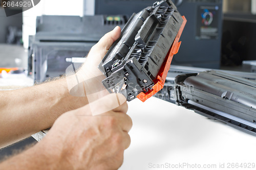 Image of Hands repairing toner cartridge