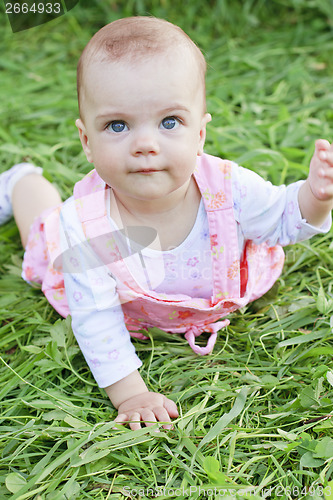 Image of Happy baby girl lying on grass