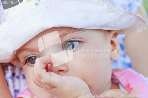 Image of Thinking baby girl with her finger in mouth