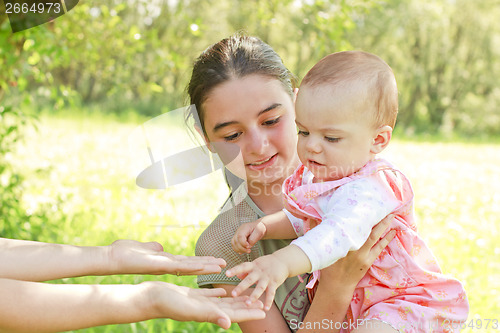 Image of Teenage girl with a baby in her arms