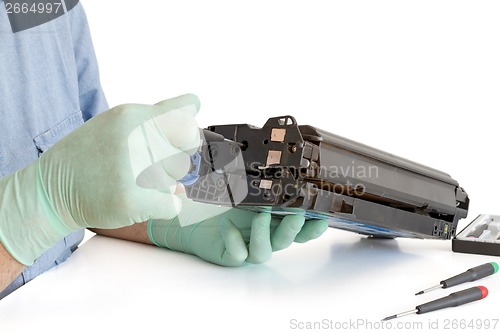 Image of hands repairing toner cartridge