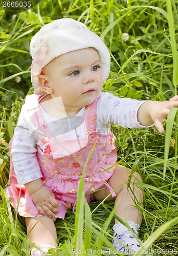 Image of Curious baby girl on grass
