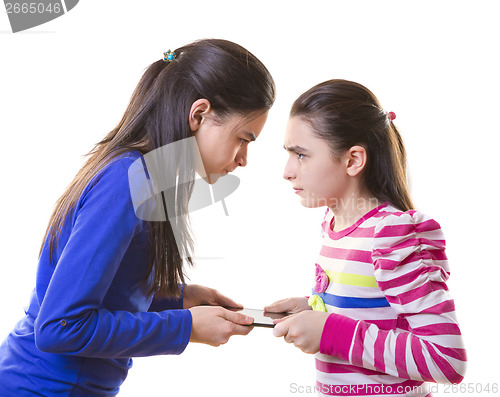 Image of Teen girls fighting for digital tablet 