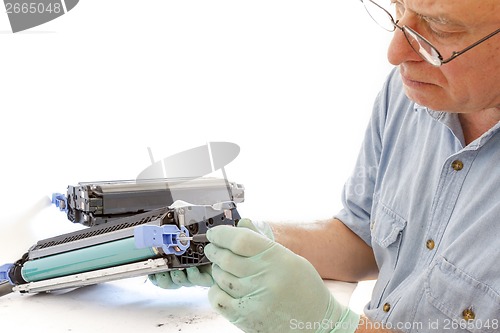 Image of adult man working toner cartridge