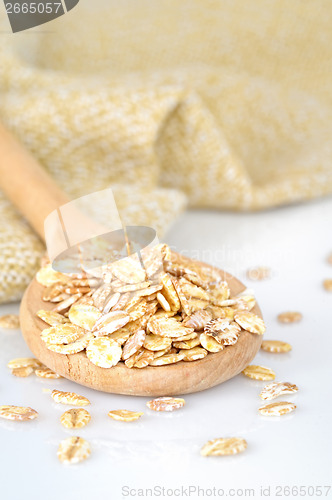 Image of close up of oat flakes in wooden spoon 