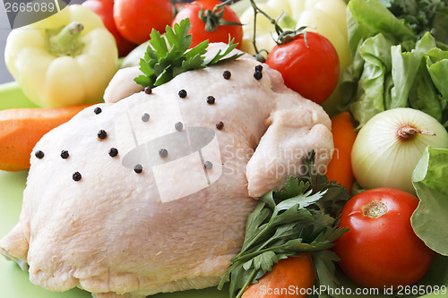 Image of Whole raw chicken with vegetables and pepper